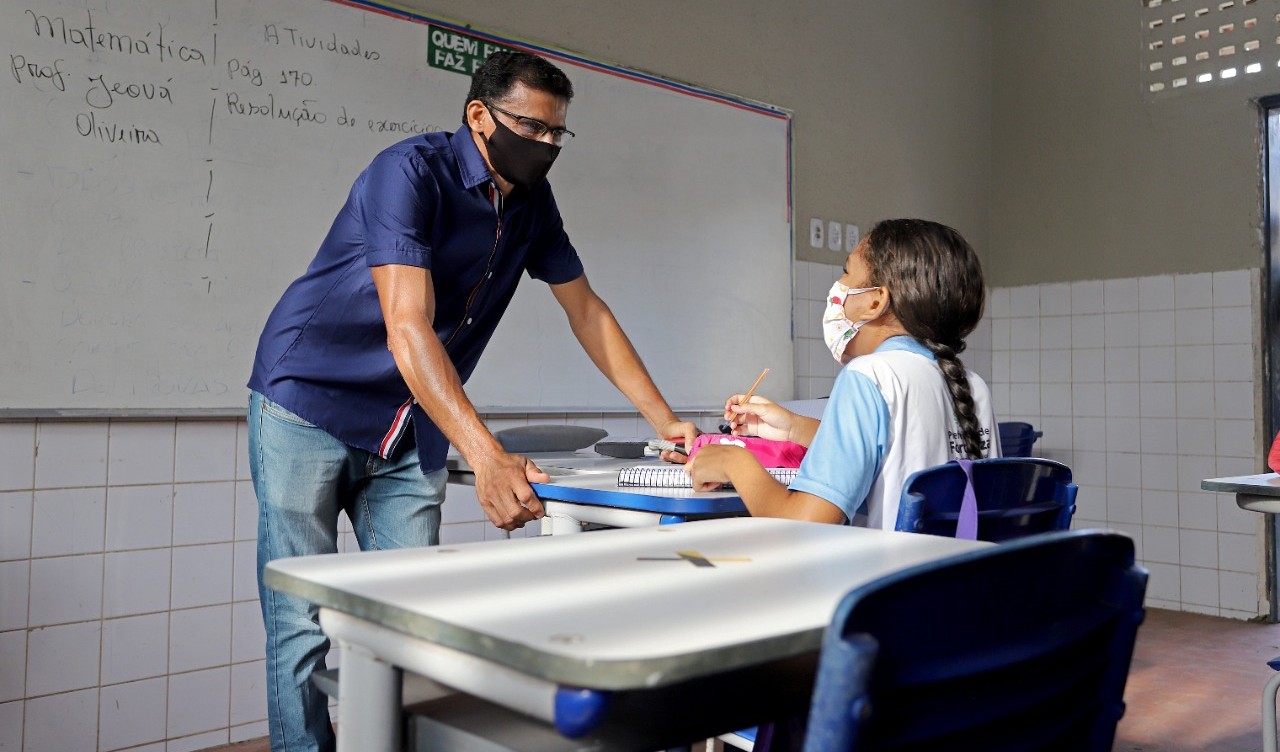 professor conversa com aluna na sala de aula